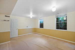 Carpeted spare room featuring baseboards and visible vents