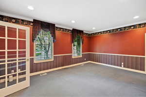Carpeted spare room featuring crown molding, a wainscoted wall, and recessed lighting