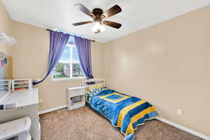 Bedroom featuring baseboards, carpet flooring, and ceiling fan