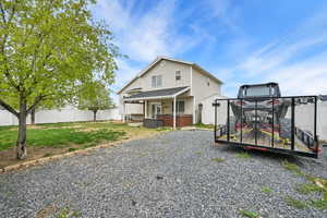 Exterior space with a fenced backyard, a front lawn, and a hot tub