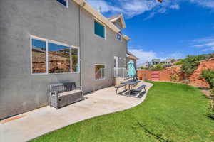 Rear view of property with fence, a patio area, a lawn, and stucco siding