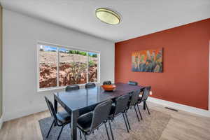 Dining area featuring baseboards, visible vents, and light wood-style flooring