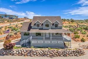 View of front of home with stucco siding, a porch, stairs, and a shingled roof