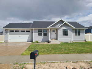 View of front of home with a garage, driveway, and roof with shingles