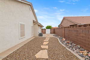 View of yard featuring a gate, central AC, and a fenced backyard