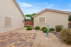 View of side of property featuring fence, a patio area, and stucco siding