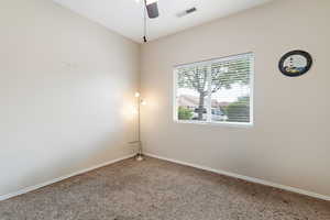 Unfurnished room with carpet, visible vents, a ceiling fan, and baseboards