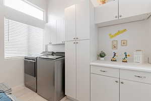 Laundry area featuring cabinet space, baseboards, and separate washer and dryer