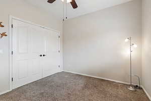 Unfurnished bedroom featuring a ceiling fan, baseboards, and carpet