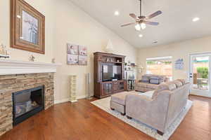 Living room featuring visible vents, recessed lighting, a ceiling fan, wood finished floors, and a stone fireplace