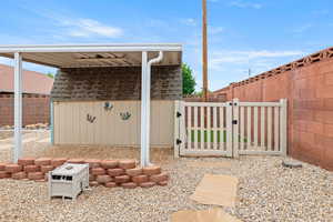 View of patio / terrace featuring a storage shed, a fenced backyard, an outdoor structure, and a gate