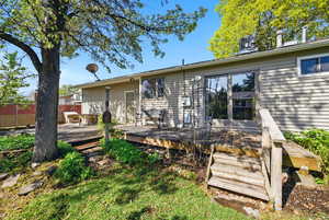 Back of house with a wooden deck, fence, and cooling unit