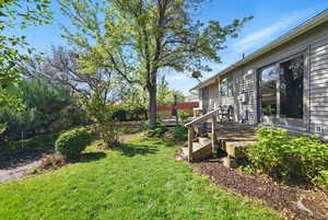 View of yard with a wooden deck and fence