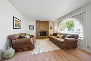 Carpeted living area with wallpapered walls and a fireplace