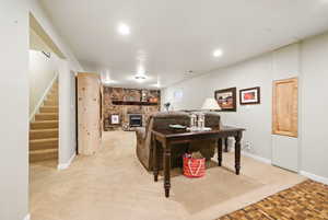 Living area featuring recessed lighting, baseboards, a fireplace, and stairs