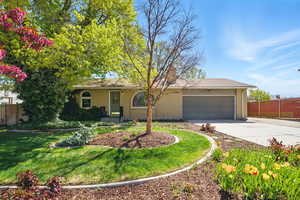 Ranch-style home featuring fence, an attached garage, brick siding, and concrete driveway