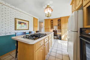 Kitchen featuring wallpapered walls, black appliances, open shelves, light countertops, and light tile patterned floors