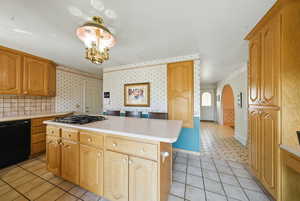 Kitchen with arched walkways, black dishwasher, wallpapered walls, light countertops, and light tile patterned floors