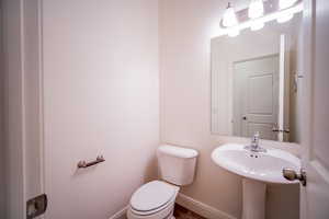 Half bathroom with baseboards and toilet