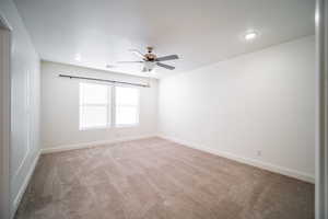 Unfurnished room with visible vents, a ceiling fan, baseboards, and light colored carpet