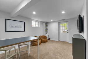 Carpeted office space with baseboards, visible vents, recessed lighting, and a wealth of natural light