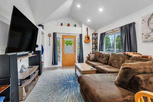 Living room with lofted ceiling, wood finished floors, and recessed lighting
