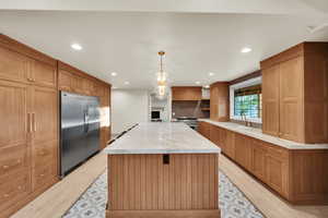 Kitchen featuring light wood-type flooring, a center island, premium appliances, and recessed lighting