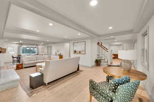 Living area featuring baseboards, wood finished floors, recessed lighting, and stairway