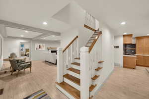 Stairs with wood finished floors, a fireplace, baseboards, visible vents, and recessed lighting