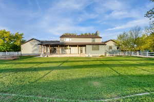 Rear view of property with fence, a lawn, a chimney, and a patio area