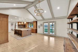 Kitchen with recessed lighting, brown cabinets, an inviting chandelier, light countertops, and beamed ceiling