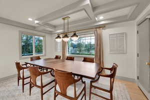 Dining space featuring baseboards, coffered ceiling, light wood finished floors, and recessed lighting