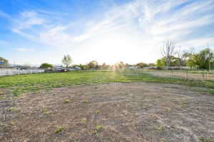 View of yard with a rural view and fence