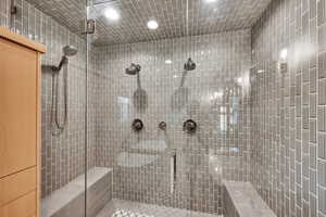 Bathroom with tile patterned flooring, recessed lighting, and a tile shower
