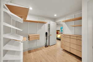 Walk in closet with light wood-type flooring
