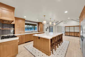 Kitchen featuring light wood-style floors, a kitchen island, recessed lighting, and tasteful backsplash