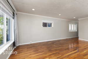 Spare room with wood finished floors, a textured ceiling, and recessed lighting
