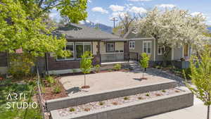 View of front facade with brick siding, roof with shingles, and a mountain view
