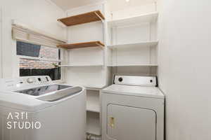 Washroom featuring independent washer and dryer and laundry area