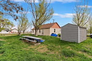 View of yard with an outbuilding and a shed