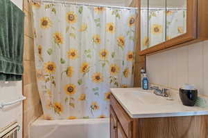 Bathroom featuring shower / bath combo with shower curtain and vanity
