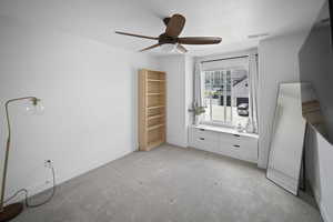 Unfurnished bedroom featuring ceiling fan, visible vents, baseboards, and light carpet