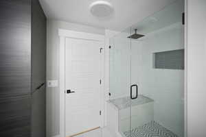Bathroom with tile patterned floors and a shower stall