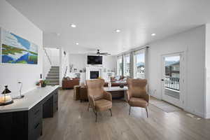 Living area with light wood-style flooring, visible vents, recessed lighting, stairway, and a fireplace