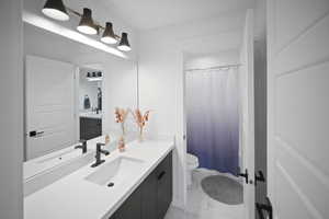 Full bathroom with marble finish floor, vanity, and toilet