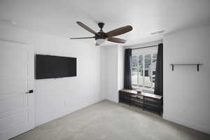 Unfurnished bedroom featuring baseboards, visible vents, carpet flooring, and ceiling fan