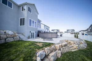 View of yard featuring a fenced backyard, french doors, a hot tub, and a patio