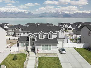 Exterior space with a water and mountain view, driveway, fence, and board and batten siding
