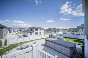 Exterior space with a patio area, a fenced backyard, a hot tub, and a residential view