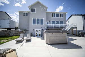 Rear view of house featuring stairway, french doors, a hot tub, and a patio